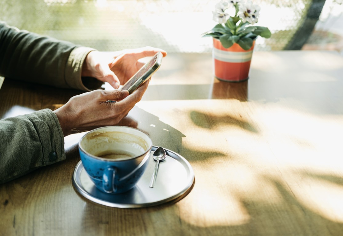 Person searching for a local business on their phone at a cafe
