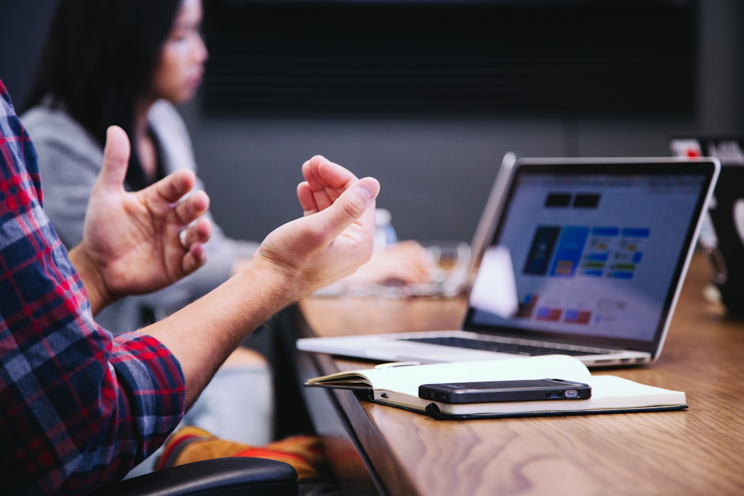 seo vs geo — person gesturing during meeting with laptop